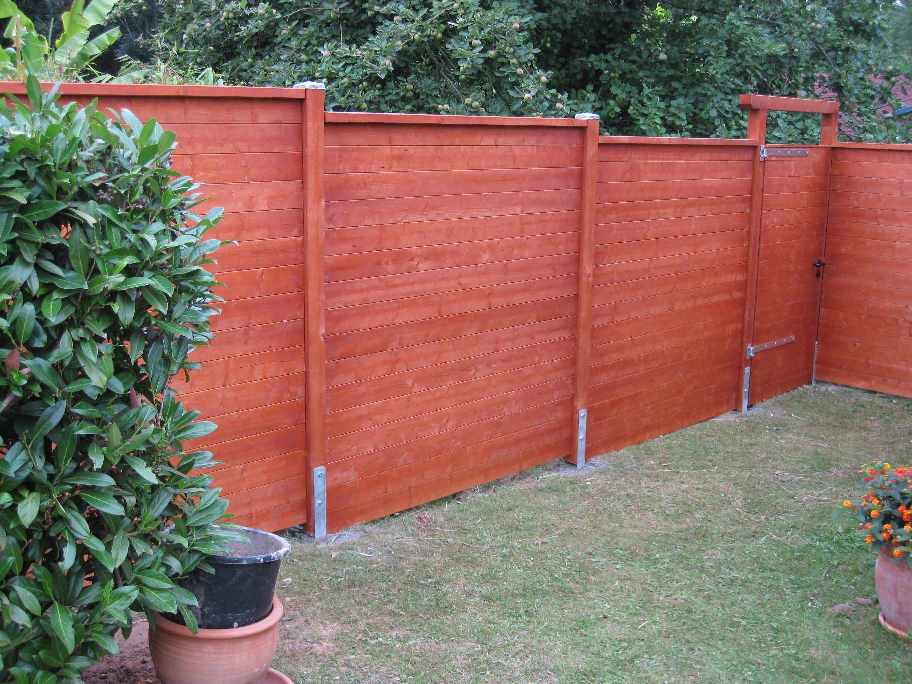 geschlossener Sichtschutz aus Carportprofilen. Farbton Teak